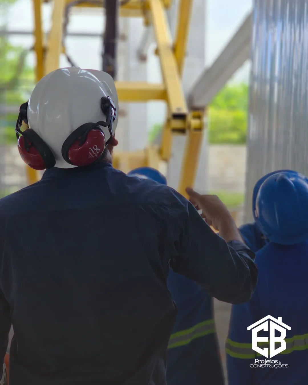 Profissionais com capacete e protetor auricular acompanhando a frente de serviço
