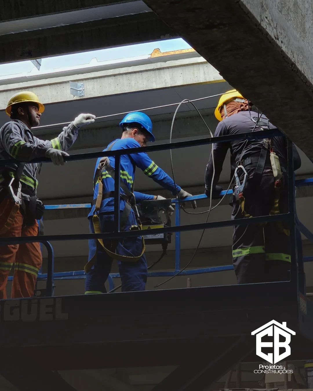 Equipe com cinto de segurança em plataforma elevatória